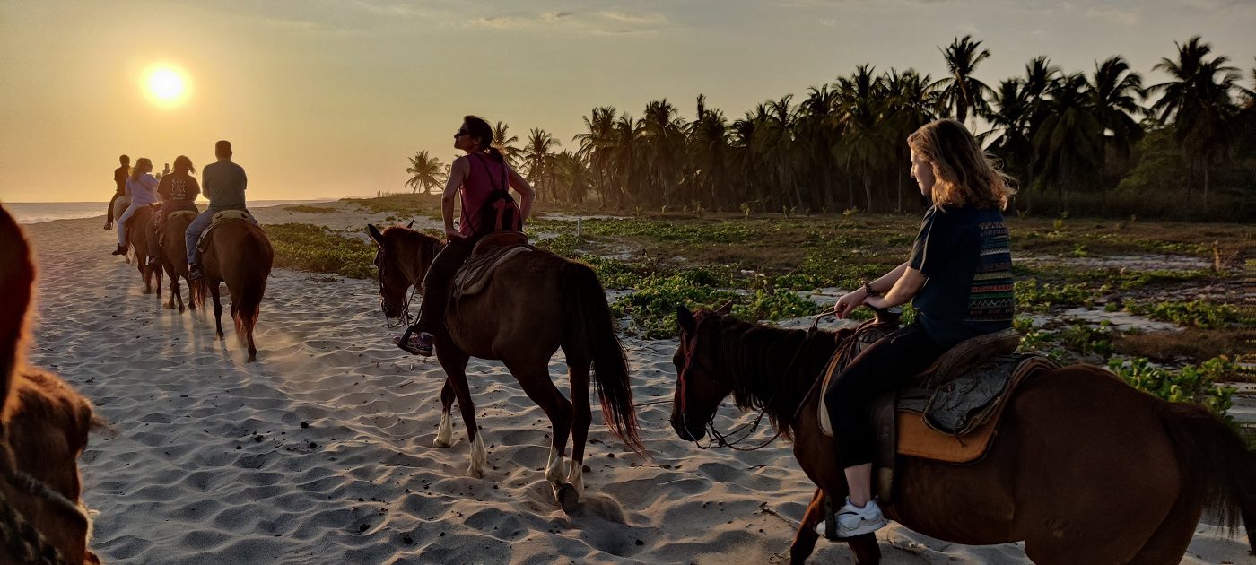 Horseback riding sunset beach